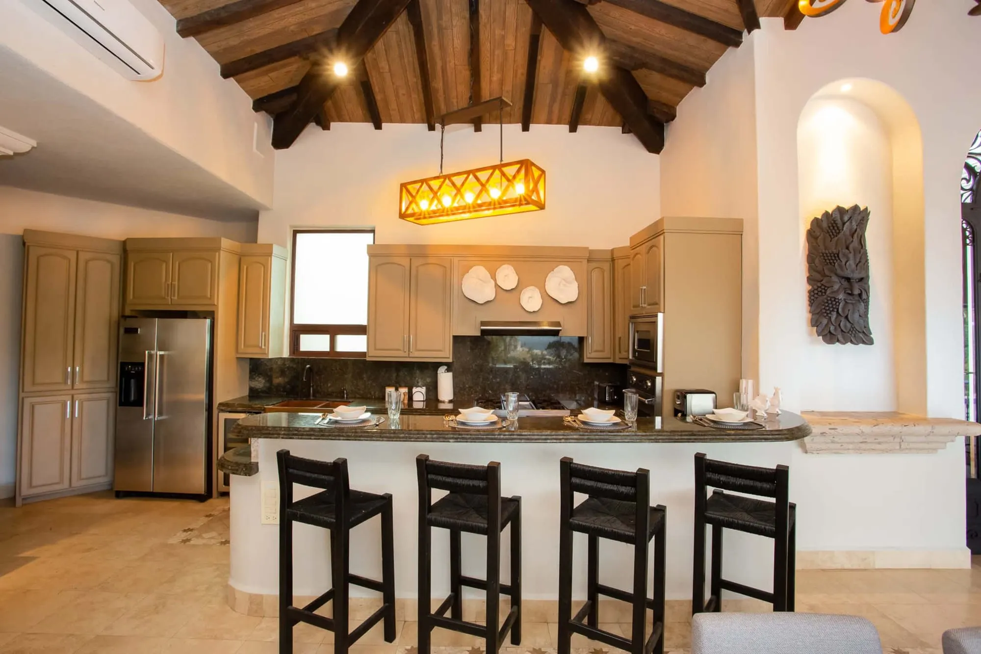 The kitchen under an open beamed ceiling, with a breakfast bar
