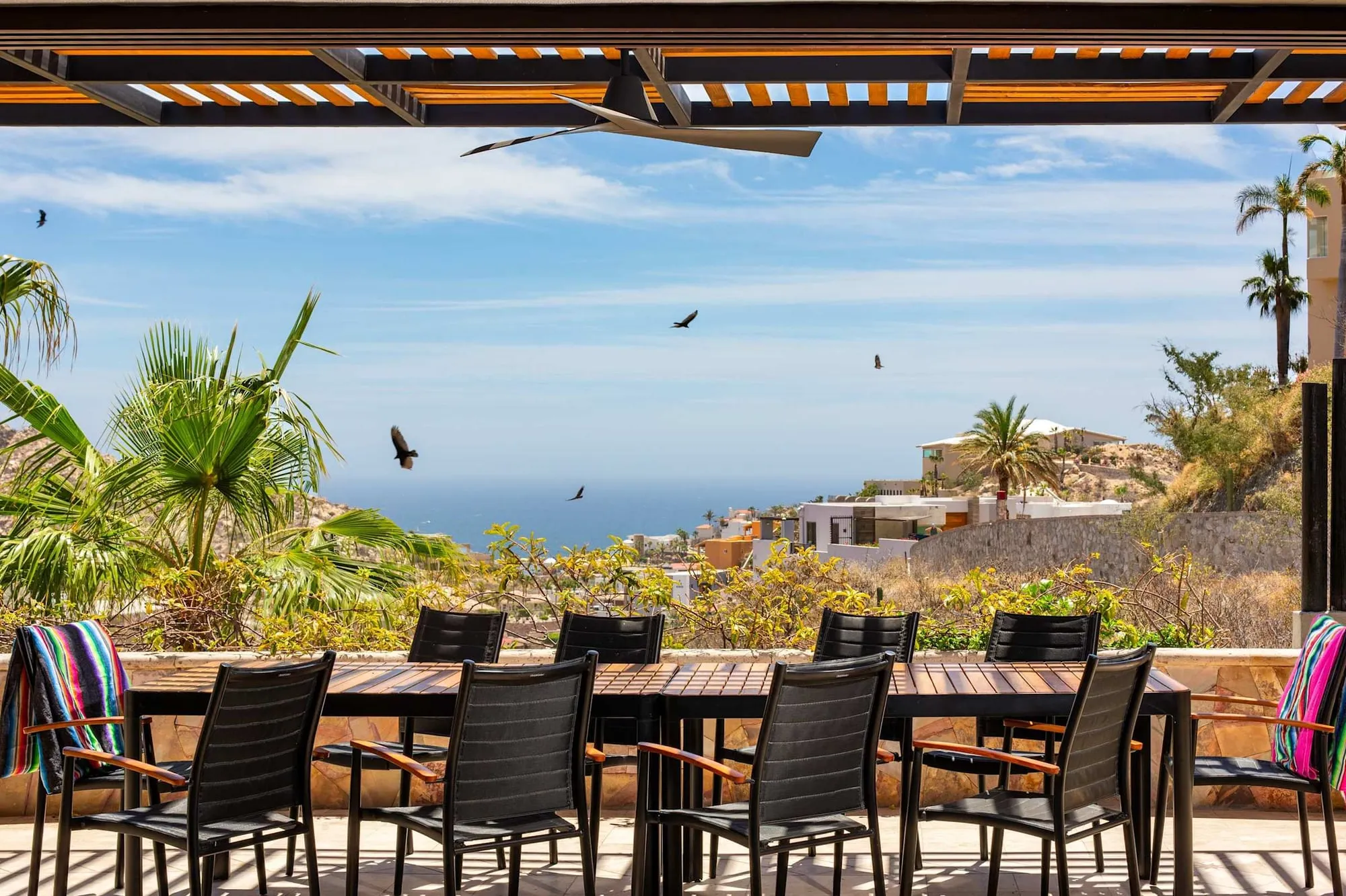 A long dining table set on the terrace above the water at the Pedregal villa
