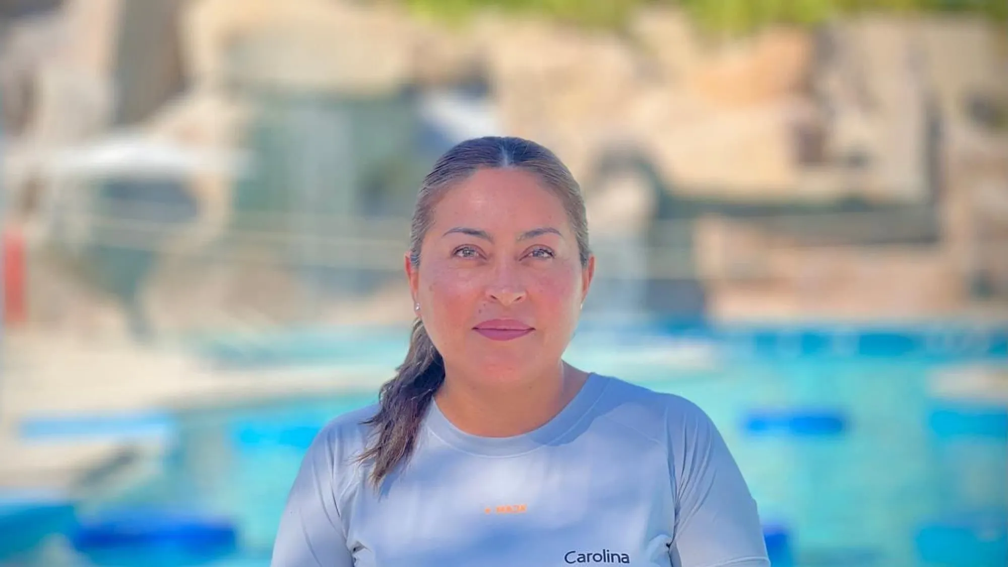 Carolina Silva, who founded Lúdica, in her work polo beside a pool